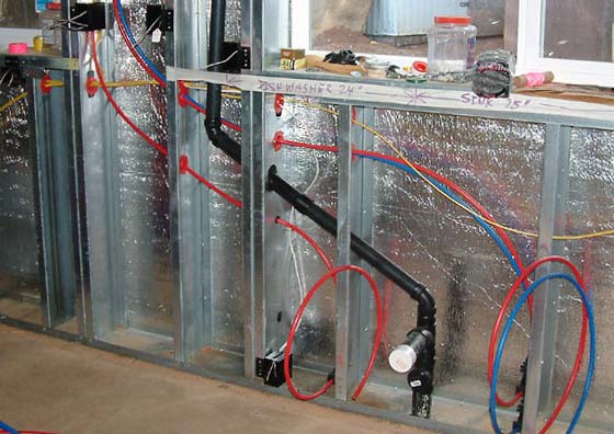 Plumbing and wiring run through steel studs