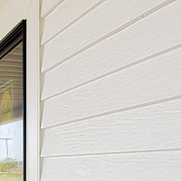 Steel siding with clapboard profile and raised, wood-grain finish